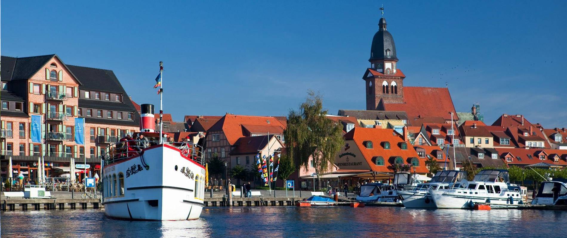Idyllische Seenlandschaft mit Booten und Blick auf die Stadt